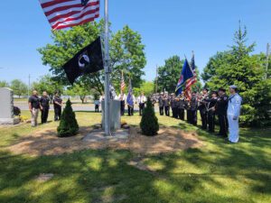 Ceremony with flags and uniformed individuals outdoors.